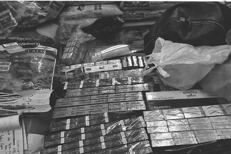 A black and white photo showing a stack of tobacco and drugs