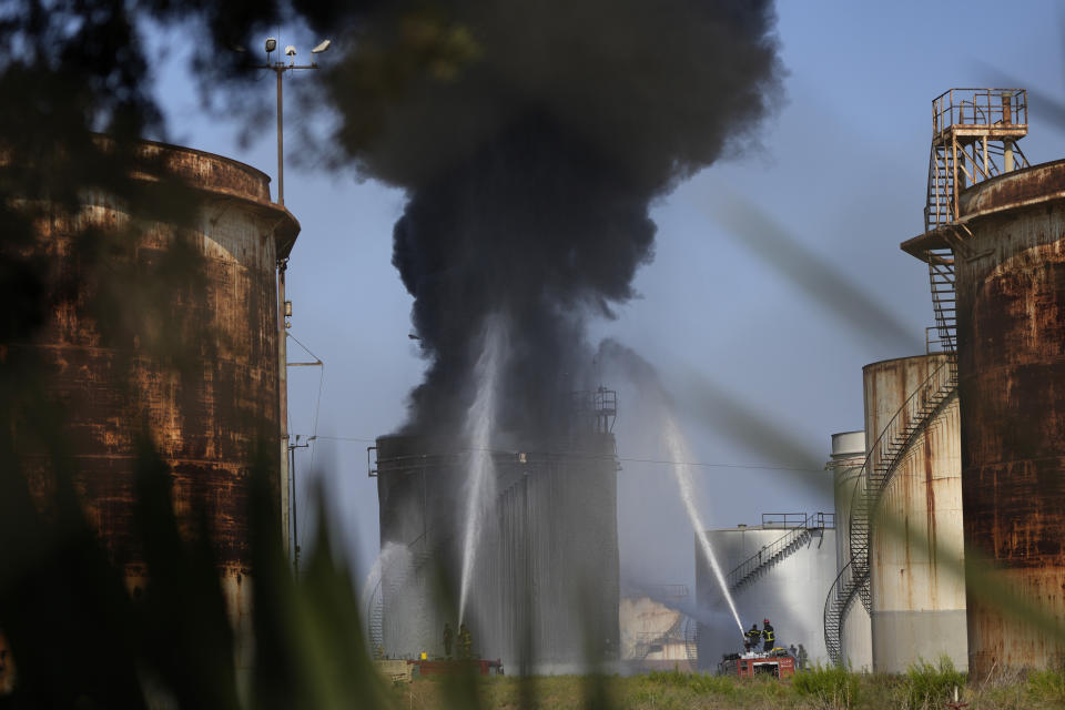 Firefighters work to extinguish a fire in an oil facility in the southern town of Zahrani, south of the port city of Sidon, Lebanon, Monday, Oct. 11, 2021. A huge fire broke out at an oil facility in southern Lebanon's coastal town of Zahrani, but the cause was not immediately known. (AP Photo/Hassan Ammar)