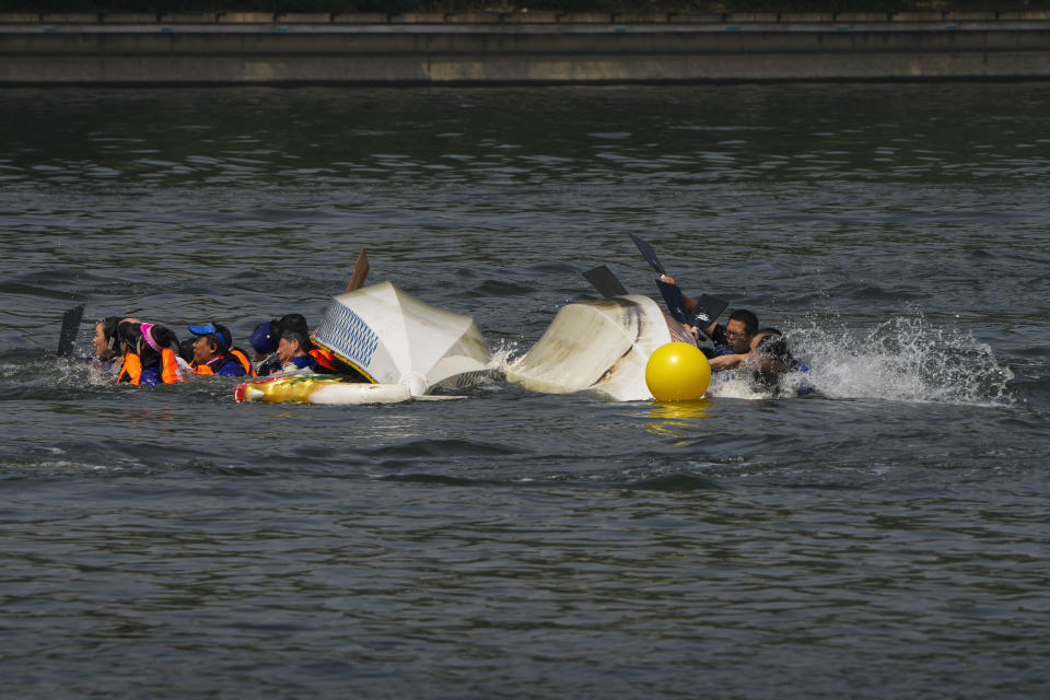 Competitors fall as the boats overturned following a crash during the Dragon Boat Festival at a canal in Tongzhou, outskirts of Beijing, Monday, June 10, 2024. The Duanwu Festival, also known as the Dragon Boat Festival, falls on the fifth day of the fifth month of the Chinese lunar calendar and is marked by eating rice dumplings and racing dragon boats. (AP Photo/Andy Wong)