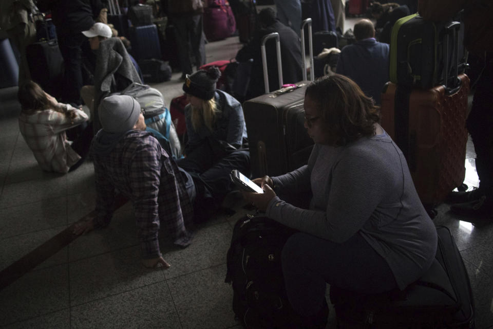 Passengers wait for the lights to come back on at Hartsfield-Jackson Atlanta International Airport Sunday, Dec. 17, 2017. A power outage at the airport disrupted ingoing and outgoing flights for hours. (Steve Schaefer/Atlanta Journal-Constitution via AP)