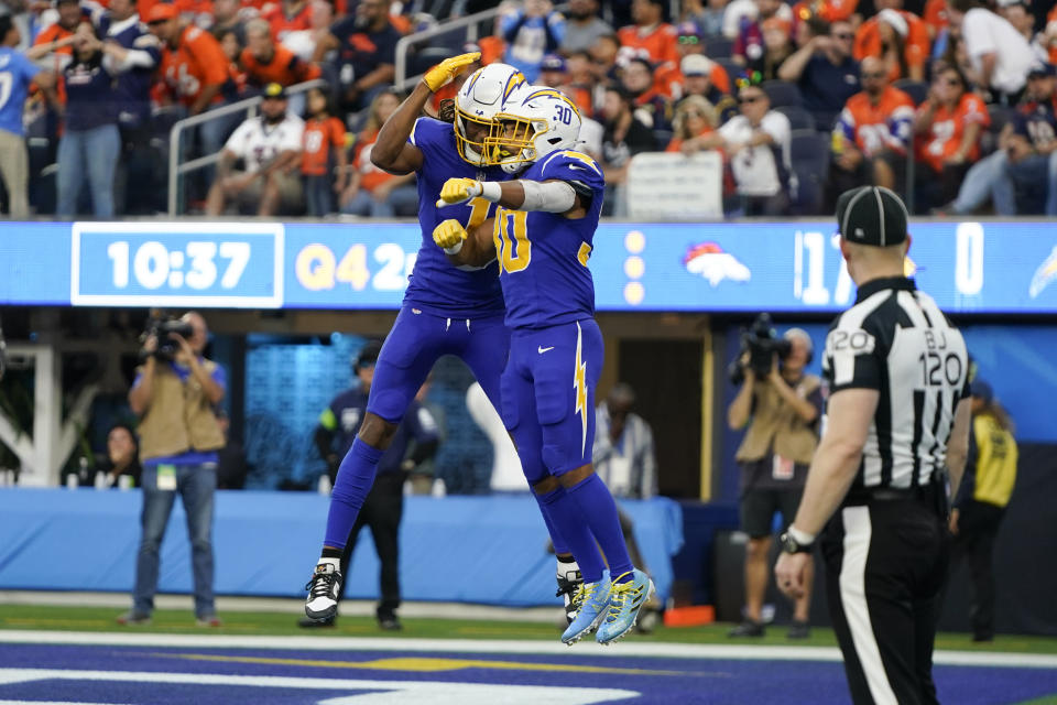 Los Angeles Chargers wide receiver Quentin Johnston (1) celebrates with running back Austin Ekeler (30) after Ekeler scored a touchdown during the second half of an NFL football game against the Denver Broncos, Sunday, Dec. 10, 2023, in Inglewood, Calif. (AP Photo/Ryan Sun)