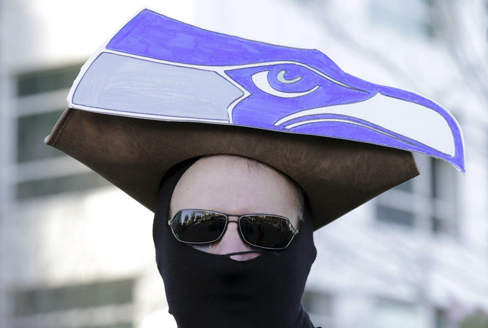 A Seattle Seahawks fan waits in the cold for the start of the Super Bowl champions parade to begin Wednesday, Feb. 5, 2014, in Seattle. The Seahawks beat the Denver Broncos 43-8 in NFL football's Super Bowl XLVIII on Sunday. (AP Photo/John Froschauer)