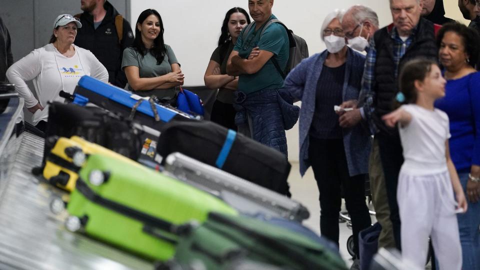 People wait for their bags in Charlotte, N.C., 3/25/23.  Auto club AAA said this summer could be “one for the record books, especially at airports,” with more than 43 million Americans projected to travel 50 miles or more.  (AP Photo)