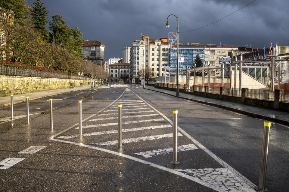 Poles block entry to one part of the city, with apartment builds in the distance.