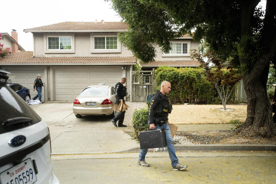 FILE - In this July, 29, 2019, file photo, police officers carry evidence bags from the family home of Gilroy Garlic Festival gunman Santino William Legan, in Gilroy, Calif. In the days and weeks since three high-profile shootings took the lives of more than two dozen people in just a week's time, law enforcement authorities have reported seeing a spike in the number of tips they are receiving from concerned relatives, friends and co-workers of people who appear bent on carrying out the next mass shooting. (AP Photo/Noah Berger, File)