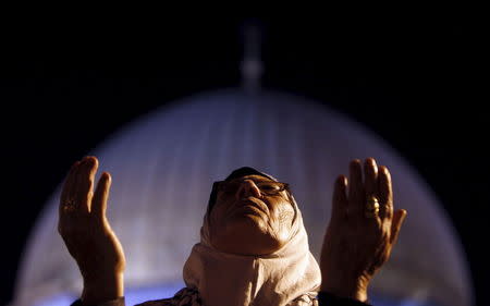 A Muslim woman prays during Laylat al-Qadr in front of the Dome of the Rock, on the compound known to Muslims as al-Haram al-Sharif (Noble Sanctuary) and to Jews as Temple Mount, in Jerusalem's Old City during the holy month of Ramadan in this August 14, 2012 file photo. REUTERS/Ammar Awad/Files