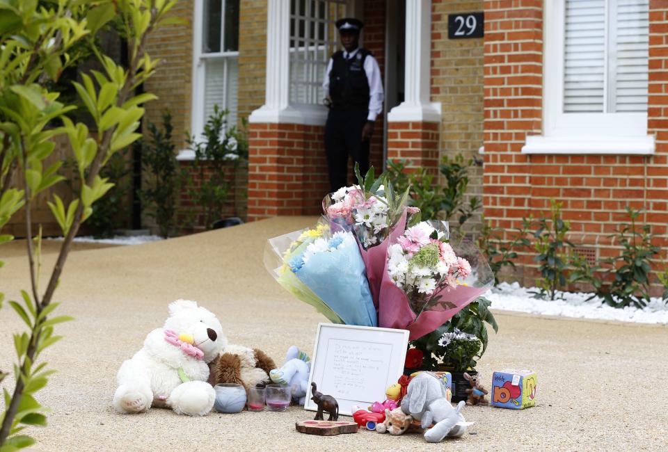 Flowers and toys are seen outside a house where the bodies of three children were found, in New Malden, southwest London