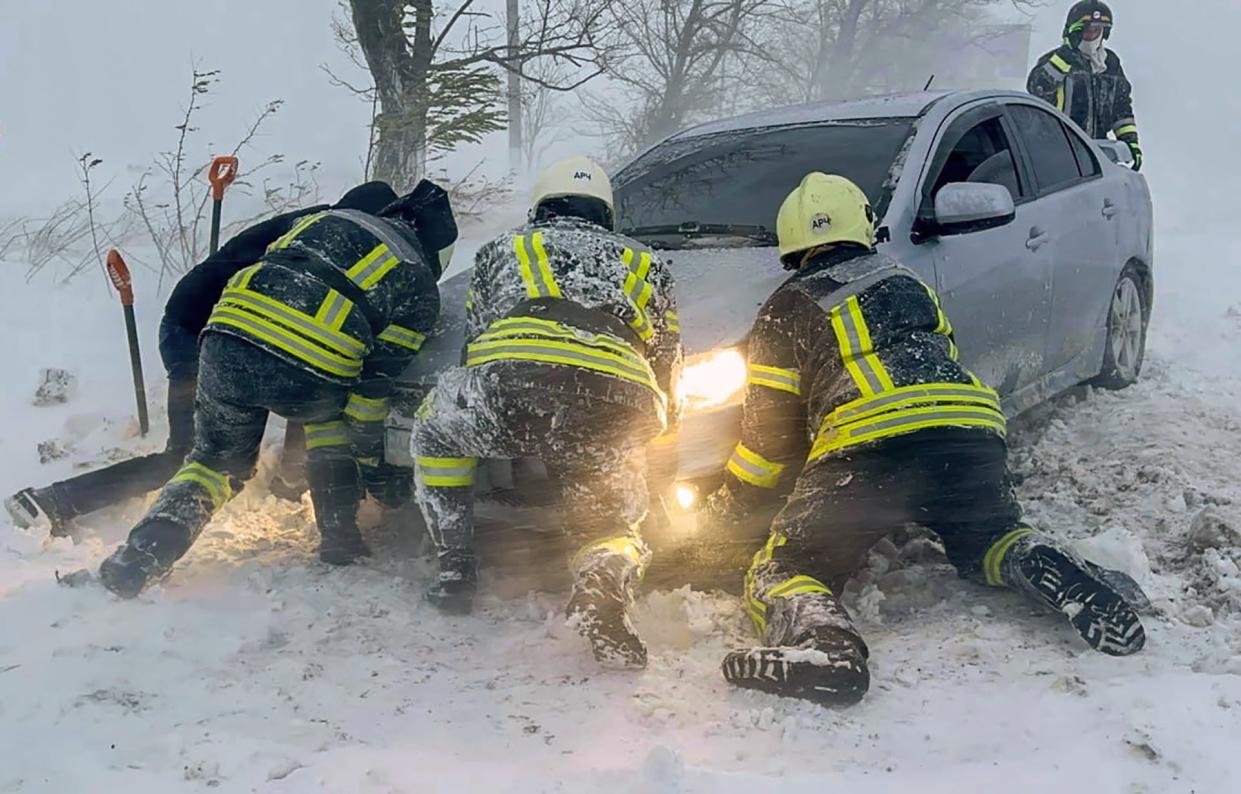 Ukrainian rescuers assisting stranded following overnight snowfall in the Odesa region (EPA)