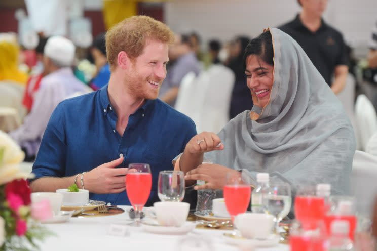 Britain's Prince Harry speaks to Nazhath Faheema, a Muslim Youth Ambassador of Peace, as they eat an evening meal to break fast, or the iftar, for Ramadan - the Muslim fasting month, during a visit to a children's home, June 4, 2017 in Singapore. REUTERS/Joseph Nair/Pool