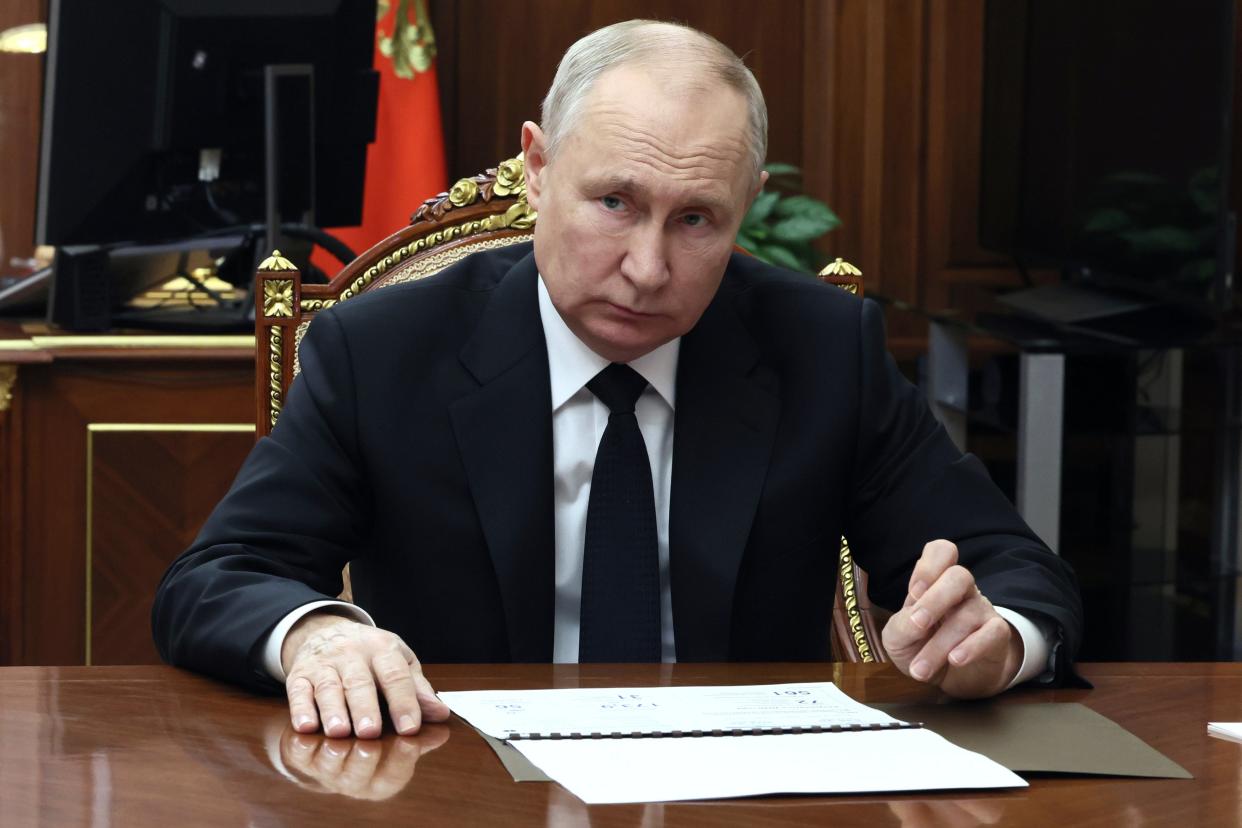 Russian president Vladimir Putin listens to Russian deputy prime minister (AP)
