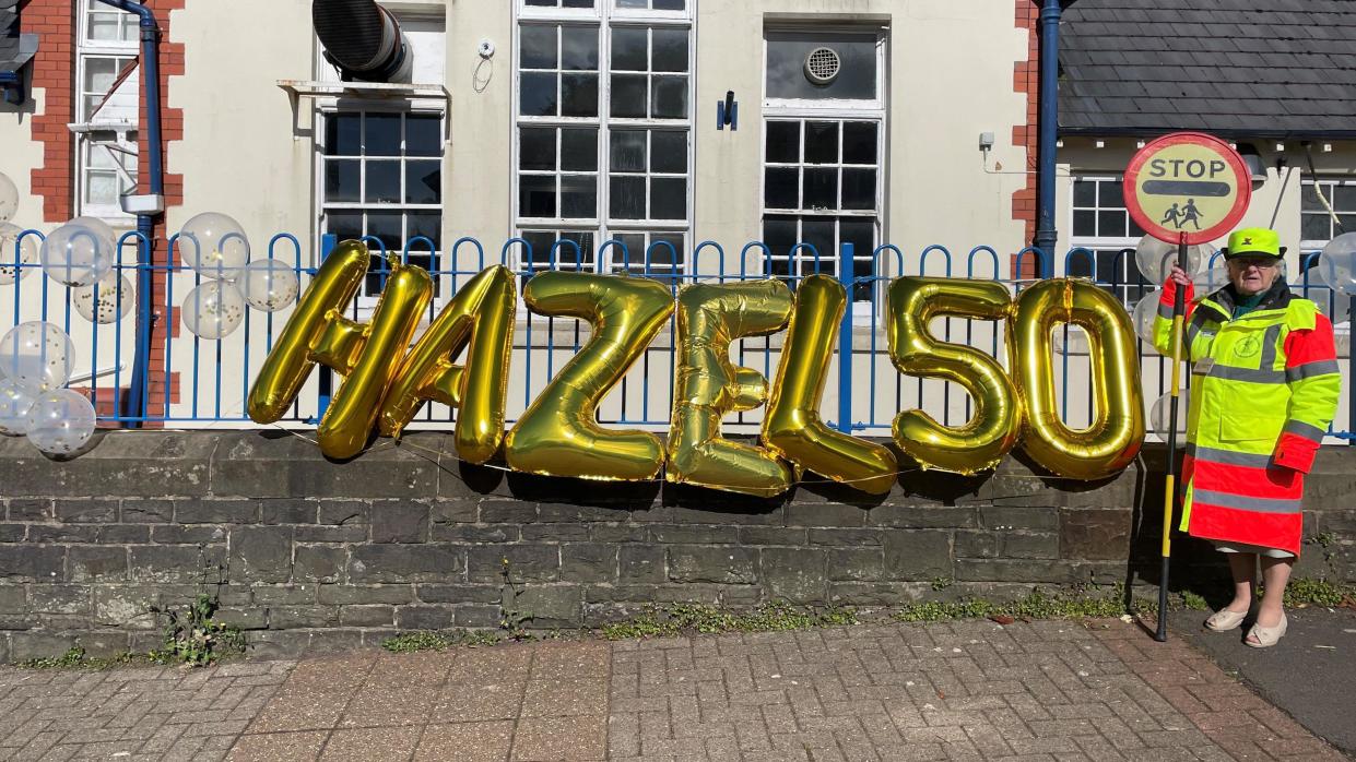 Hazel Davies with celebration balloons outside school