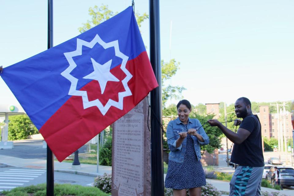 Joanna Kelley, a Seacoast African American Cultural Center board member, and Clifton West Jr., executive director of Black Lives Matter Seacoast, raise the Juneteenth flag in Somersworth on Thursday, June 17, 2021.
