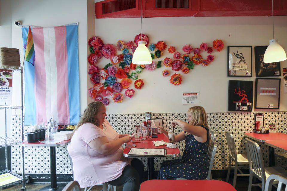 Jennilyn, left, and Flower Nichols, an 11-year-old transgender girl, eat at a restaurant during a visit to Chicago on June 13, 2023. Families around the U.S. are scrambling to navigate new laws that prohibit their transgender children from accessing gender-affirming care. At least 20 states are moving to ban or restrict such care for minors. (AP Photo/Teresa Crawford)