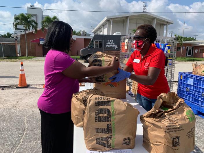 Ruth Mageria hands a bag of food to a client in need at a food distribution event in 2020. Between March and November 2020 the agency served 6,912 new individuals who had never requested food assistance before.