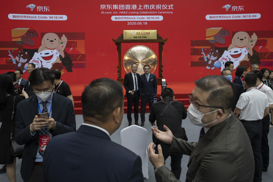 Xu Lei, head of JD Retail, center right, poses for photos with a guest before the ceremony to mark the listing of JD.com on the Hong Kong Stock Exchange at the JD.com headquarters in Beijing on Thursday, June 18, 2020. Chinese e-commerce firm JD.com's stock jumped nearly 6% on its debut in Hong Kong on Thursday after the firm raised $3.9 billion in a share sale. (AP Photo/Ng Han Guan)