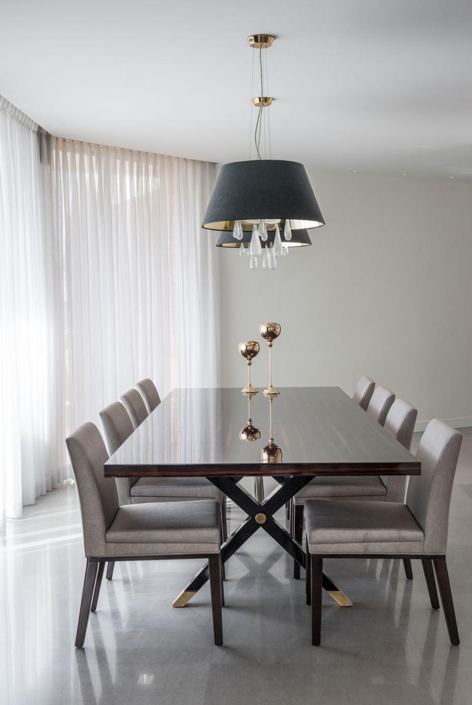 Dining room featuring a high-gloss ebony table with brass details