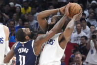 Dallas Mavericks guard Kyrie Irving, left, reaches in on Los Angeles Clippers guard James Harden during the second half in Game 5 of an NBA basketball first-round playoff series Wednesday, May 1, 2024, in Los Angeles. (AP Photo/Mark J. Terrill)