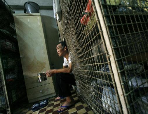 Kong Siu-kau toma una taza de té en una jaula del distrito de Tai Kok Tsui, en Hong Kong. En los barrios más antiguos y pobres de la ciudad, cientos de ancianos residen hacinados en pequeños cubículos y jaulas. (Reuters)