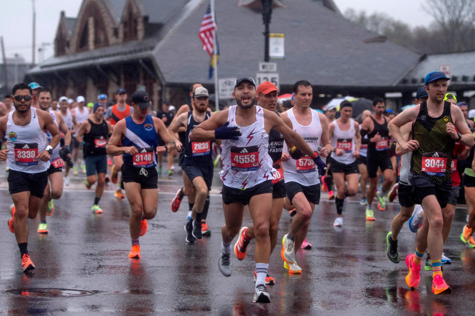 With the iconic train station building in the background, Boston Marathon runners pass by on Waverly Street in Framingham during last year's event.