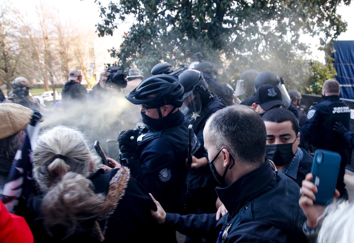 Protesters spray mace toward police as they attempt to get into the Oregon State Capitol during a special session of the state legislature in Salem, Ore., on Monday, Dec. 21, 2020. State police declared an unlawful assembly at Oregonâ€™s Capitol building as protesters opposed to COVID-19 restrictions attempted to force their way in during the third special legislative session. (Abigail Dollins/Statesman-Journal via AP) (AP)