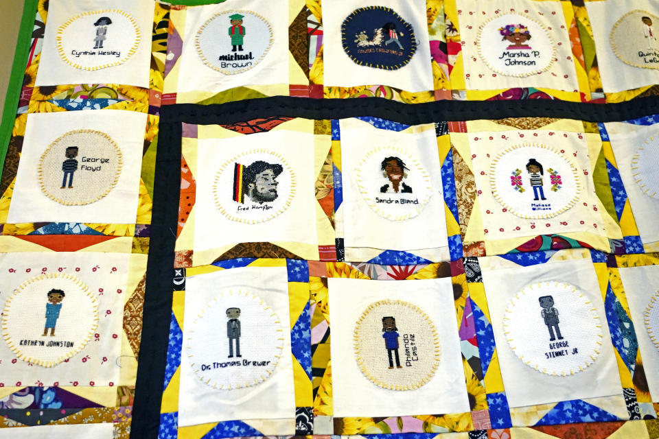 A section of two hand crafted quilts adorned with more than 115 cross-stitched portraits honoring African Americans who lost their lives to racial violence, is photographed while on display at the Margaret Walker Center on the Jackson State University campus, Tuesday, Nov. 30, 2021, in Jackson, Miss. The quilts, stitched together by 75 artists from the U.S. and beyond, are part of the Stitch Their Name Memorial Project. (AP Photo/Rogelio V. Solis)