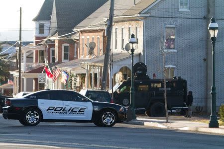 A police vehicle is seen near a home in a suburb of Philadelphia where a suspect in six killings was believed to be barricaded in Pennsburg, Pennsylvania, December 15, 2014. REUTERS/Brad Larrison