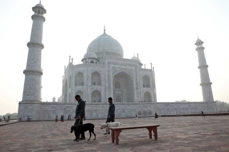 Police officers use sniffer dogs to scan the premises of the historic Taj Mahal in Agra