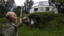 Bohumil Lhota, a 73-year-old builder, stands in front of the house which he built in Velke Hamry, near the town of Jablonec nad Nisou, 100km (62 miles) north-east from Prague, August 7, 2012. Lhota conceptualized the idea to create the unique house and started to build it in 1981, building it close to nature to benefit from the cooler ground temperature. Lhota's house, which is built in 2002, is able to move up and down and rotate on its sides, which allows him to adjust to his preferred window view. REUTERS/Petr Josek (CZECH REPUBLIC - Tags: BUSINESS CONSTRUCTION SOCIETY SCIENCE TECHNOLOGY) - RTR36EA2