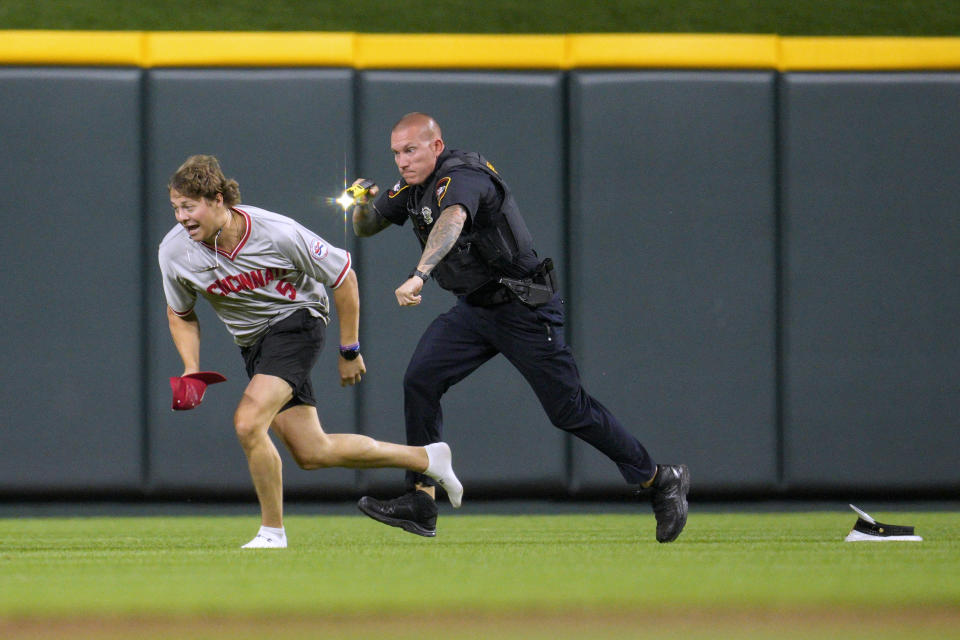 A field invader is chased by a member of security during the ninth inning of a baseball game between the Cleveland Guardians and the Cincinnati Reds in Cincinnati, Tuesday, June 11, 2024. (AP Photo/Jeff Dean)