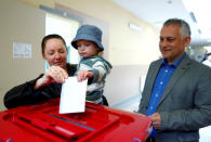 A woman holds a child as she casts her vote during European Parliament election in Riga, Latvia, May 25, 2019. REUTERS/Ints Kalnins