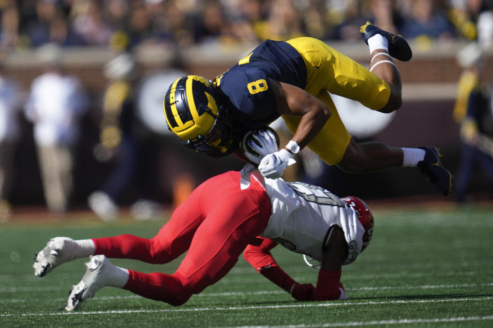 Michigan wide receiver Tyler Morris (8) is brought down after a reception by UNLV defensive back BJ Harris (27) in the first half of an NCAA college football game in Ann Arbor, Mich., Saturday, Sept. 9, 2023. (AP Photo/Paul Sancya)