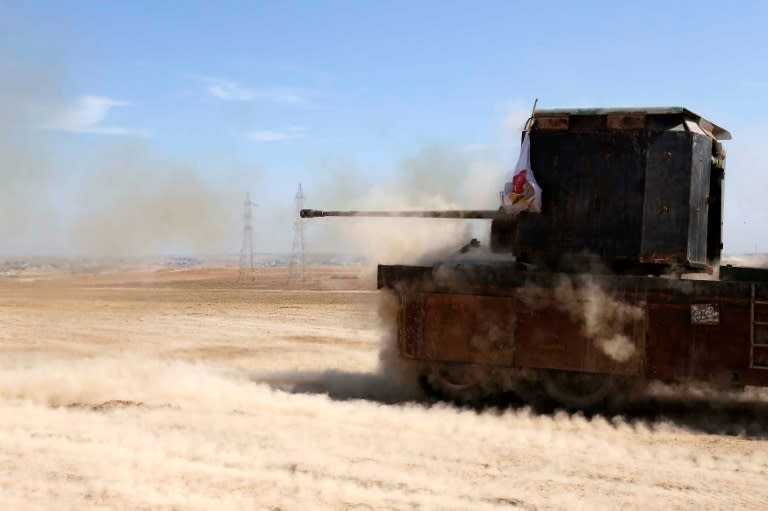 Iraqi fighters from the Abbas Brigade fire toward enemy positions from Badush