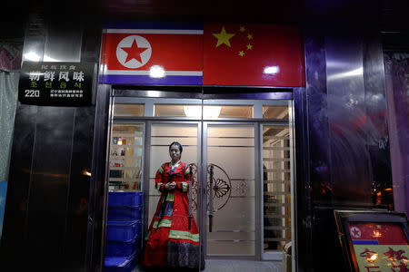 A woman in traditional dress invites customers to a North Korean restaurant on the banks of the Yalu River in Dandong, China's Liaoning province, March 30, 2017. REUTERS/Damir Sagolj