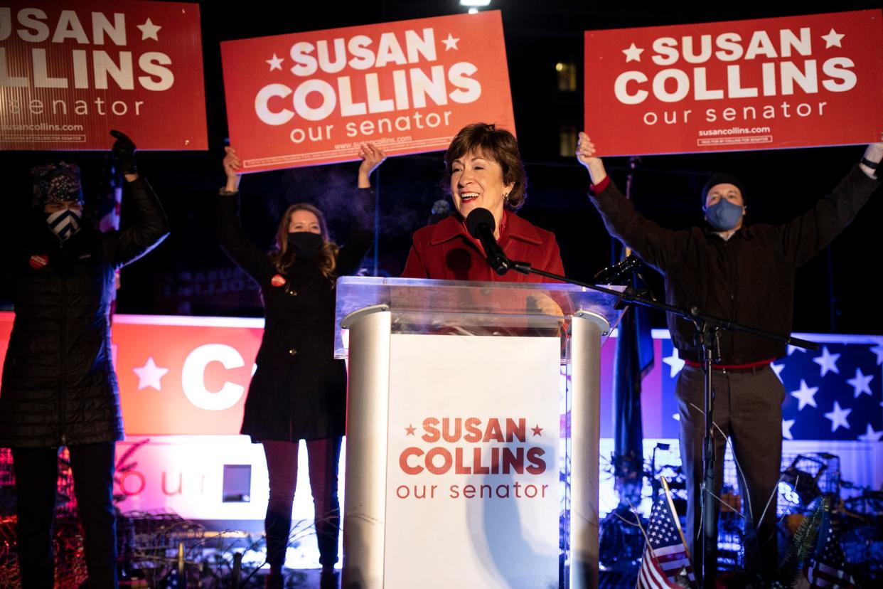 GOP Sen. Susan Collins of Maine, standing at a podium with three people behind her holding up "Susan Collins, our senator" signs,  addresses supporters on election night 2020.