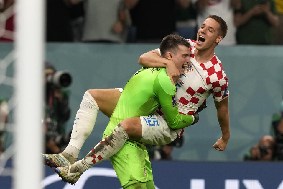 Croatia's Mario Pasalic celebrates with Croatia's goalkeeper Dominik Livakovic after scoring the final penalty at the penalty shootout of the World Cup round of 16 soccer match between Japan and Croatia at the Al Janoub Stadium in Al Wakrah, Qatar, Monday, Dec. 5, 2022. (AP Photo/Frank Augstein)