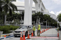 Members of the Florida National Guard monitor vehicles at a COVID-19 testing site outside of Marlins Park, Monday, July 27, 2020, in Miami. The Marlins home opener against the Baltimore Orioles on Monday night has been postponed as the Marlins deal with a coronavirus outbreak that stranded them in Philadelphia. (AP Photo/Lynne Sladky)