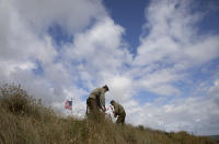 Two men in WWII period uniforms mark off an area in a dune overlooking Omaha Beach prior to a ceremony at the Charles Shay Memorial in Saint-Laurent-sur-Mer, Normandy, France, Friday, June 5, 2020. Saturday's anniversary of D-Day will be one of the loneliest remembrances ever, as the coronavirus pandemic is keeping almost everyone away, from government leaders to frail veterans who might not get another chance for a final farewell to their unlucky comrades. (AP Photo/Virginia Mayo)