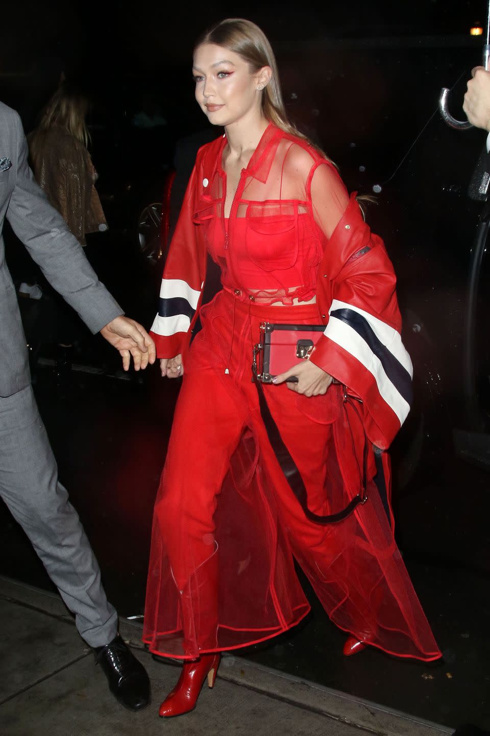 <p>In a red sheer top, pants, cowboy boots, box clutch, and Tommy Hilfiger jacket for the TommyXLewis launch party in NYC.</p>