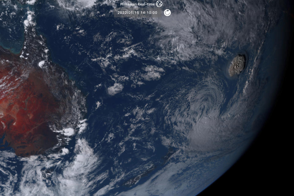 This satellite image taken by Himawari-8, a Japanese weather satellite operated by Japan Meteorological Agency and released by National Institute of Information and Communications Technology (NICT), shows an undersea volcano eruption, right, at the Pacific nation of Tonga Saturday, Jan. 15, 2022. (NICT via AP)