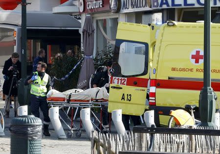 A victim is removed from the scene where shots were fired during a police search of a house in the suburb of Forest near Brussels, Belgium, March 15, 2016. REUTERS/Francois Lenoir