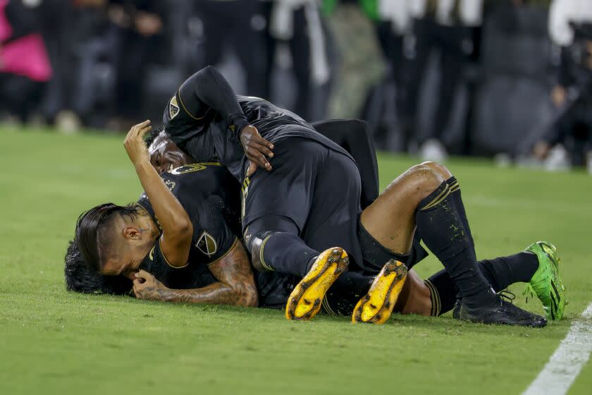 Los Angeles FC defenders Giorgio Chiellini (14) celebrates his goal with Jesus David Murillo (3) and forward Cristian Arango (9) during an MLS soccer match against the Seattle Sounders Friday, July 29, 2022, in Los Angeles. (AP Photo/Ringo H.W. Chiu)