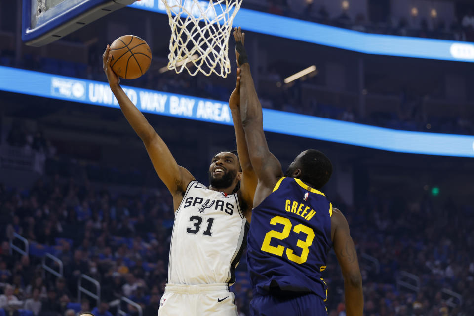 San Antonio Spurs forward Keita Bates-Diop (31) shoots against Golden State Warriors forward Draymond Green (23) during the first half of an NBA basketball game in San Francisco, Friday, March 31, 2023. (AP Photo/Jed Jacobsohn)