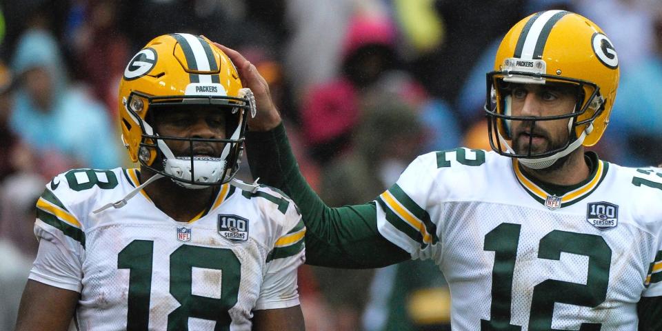 Aaron Rodgers pats the helmet of Randall Cobb during a 2018 game.