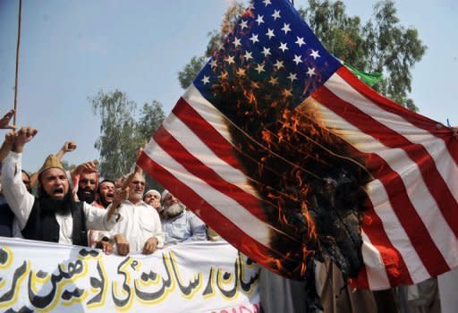 Pakistani Muslim protesters burn a US flag during a rally against an anti-Islam movie in Peshawar. Al-Qaeda said a deadly attack on US diplomats in Libya was in revenge for the killing of its number two, monitors reported