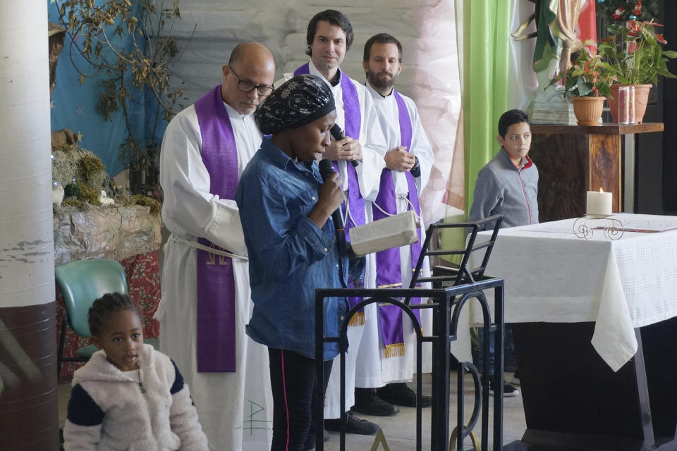 Eslande, a migrant mother from Haiti, reads the Gospel in Creole during Mass celebrated in the Casa del Migrante shelter by three Jesuit priests, from left, the Revs. Flavio Bravo, Louie Hotop and Brian Strassburger, in Reynosa, Mexico, on Dec. 15, 2022. Nearly 300 migrants from Haiti, Venezuela, and other Latin American countries are cramming the shelter, run by Catholic nuns in this border city on the Rio Grande. (AP Photo/Giovanna Dell'Orto)