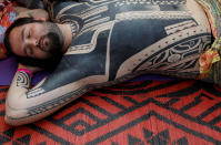 <p>A visitor to the London Tattoo Convention lies still as he has a tattoo drawn on his body with the hand-tapping method, in London, Britain, Sept. 23, 2017. (Photo: Peter Nicholls/Reuters) </p>