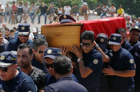 Police officers carry the coffin of their comrade during his funeral in Sidi Hassine