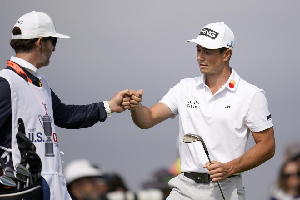Viktor Hovland, of Norway, right, fist bumps his caddy on the second green during the first round of the U.S. Open Golf Championship, Thursday, June 17, 2021, at Torrey Pines Golf Course in San Diego. (AP Photo/Gregory Bull)