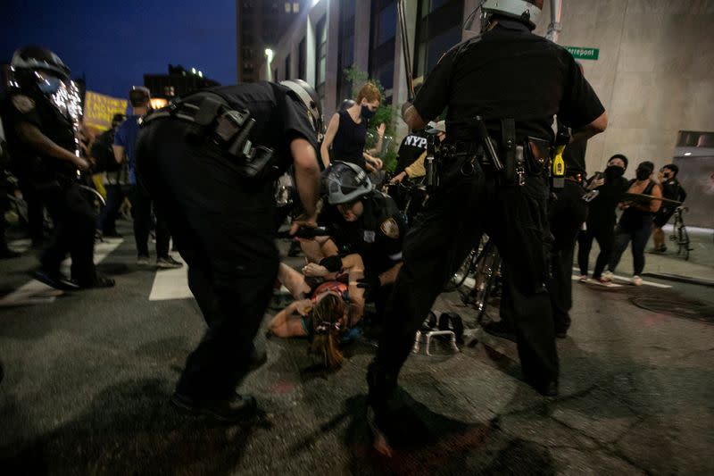 FILE PHOTO: Law enforcement officers detain a woman during a protest against the death in Minneapolis police custody of George Floyd, in Brooklyn, New York