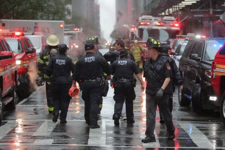 New York City police and firefighters arrive at the scene after a helicopter crashed atop a building in New York